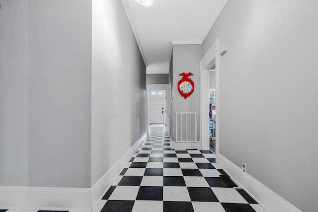 corridor featuring tile patterned floors, visible vents, baseboards, and crown molding