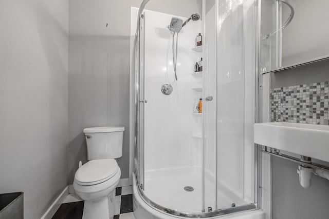 bathroom featuring tile patterned floors, an enclosed shower, and toilet