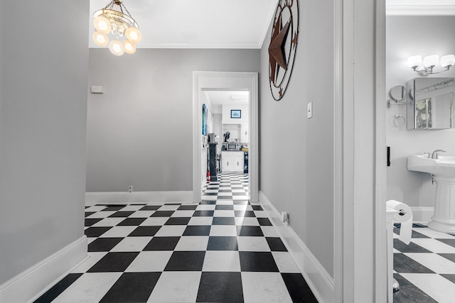 corridor featuring crown molding, tile patterned floors, a chandelier, and baseboards