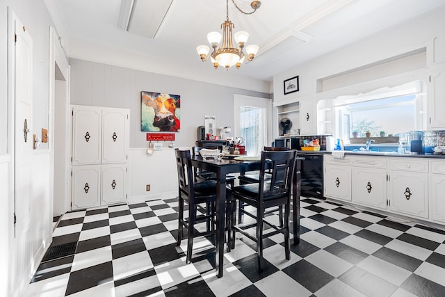 dining area featuring a healthy amount of sunlight, crown molding, sink, and a notable chandelier