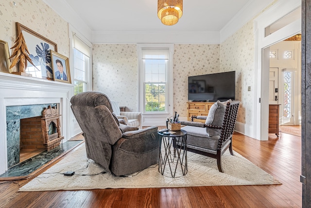 living room with ornamental molding, a high end fireplace, and hardwood / wood-style flooring