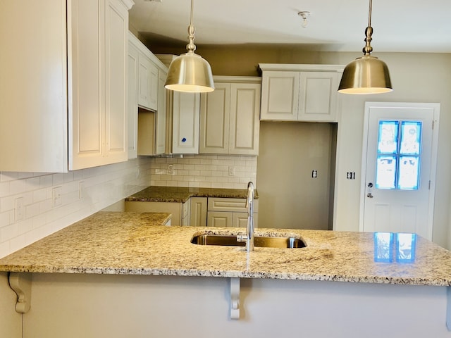 kitchen featuring white cabinetry, sink, and pendant lighting