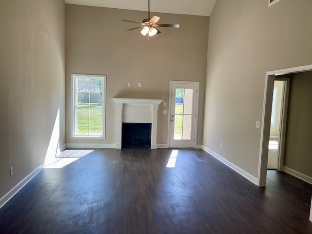 unfurnished living room with ceiling fan, dark hardwood / wood-style floors, and high vaulted ceiling