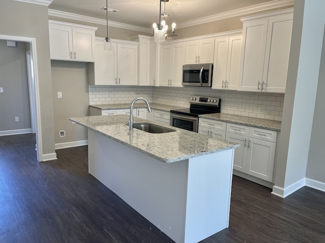 kitchen with appliances with stainless steel finishes, white cabinetry, sink, and decorative light fixtures