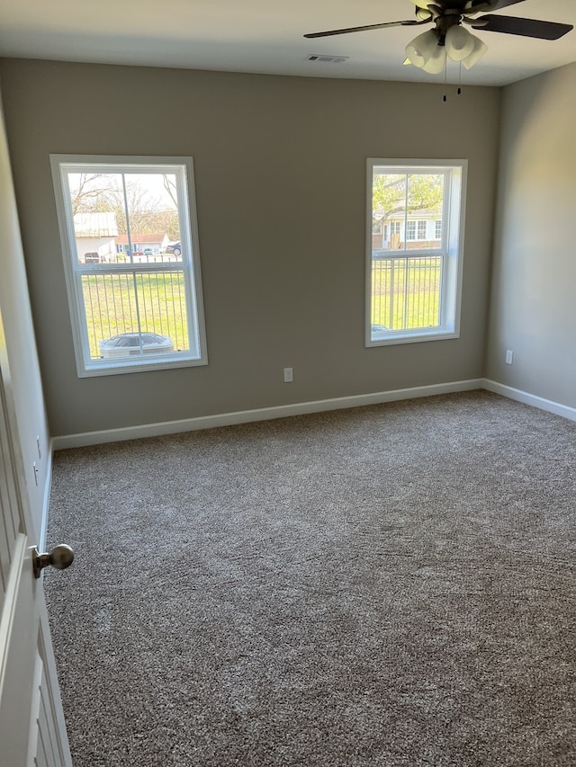 carpeted spare room with ceiling fan