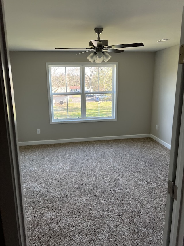 carpeted empty room featuring ceiling fan