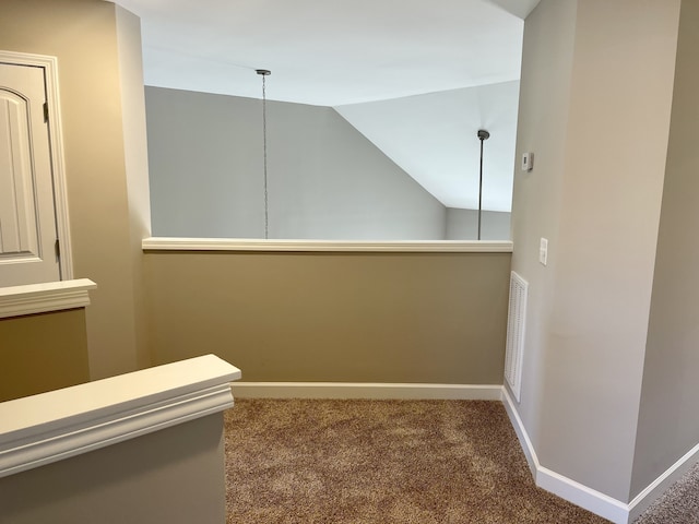 corridor with carpet floors and lofted ceiling