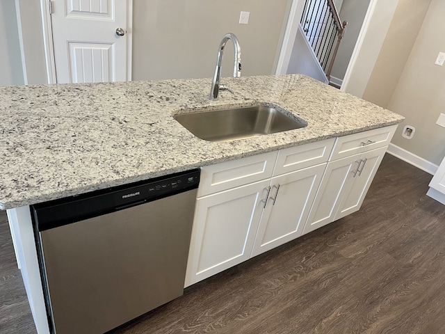 kitchen with light stone counters, white cabinets, dishwasher, and sink