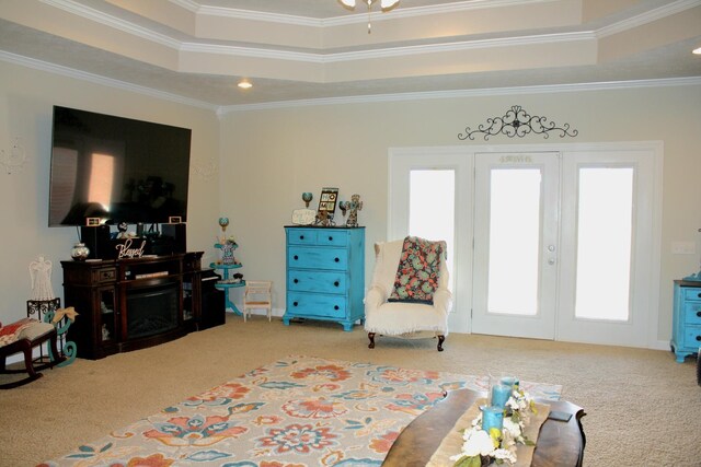 sitting room featuring carpet flooring, a tray ceiling, a fireplace, and ornamental molding