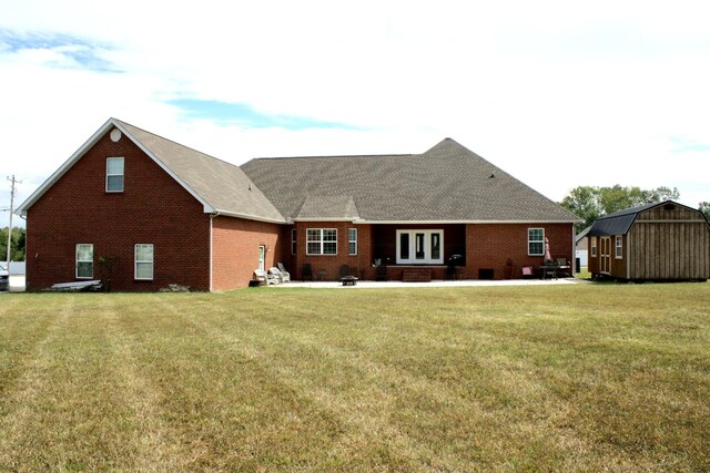 rear view of property featuring a storage shed and a yard