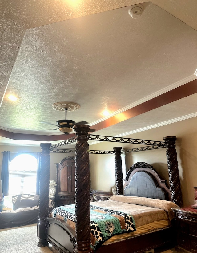 carpeted bedroom with a textured ceiling, crown molding, and ceiling fan