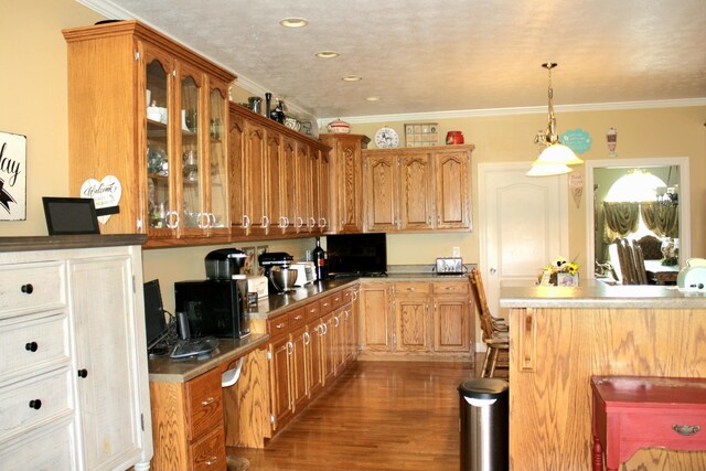 kitchen featuring ornamental molding, dark wood-type flooring, and decorative light fixtures