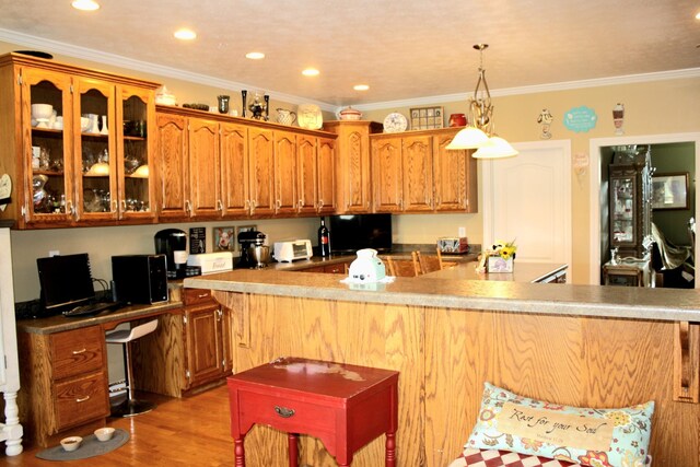 kitchen with light hardwood / wood-style flooring, hanging light fixtures, and ornamental molding