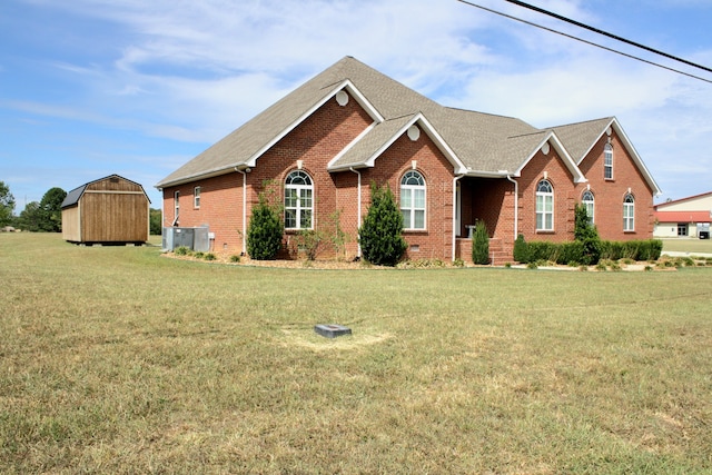 view of front of home featuring a storage unit and a front lawn