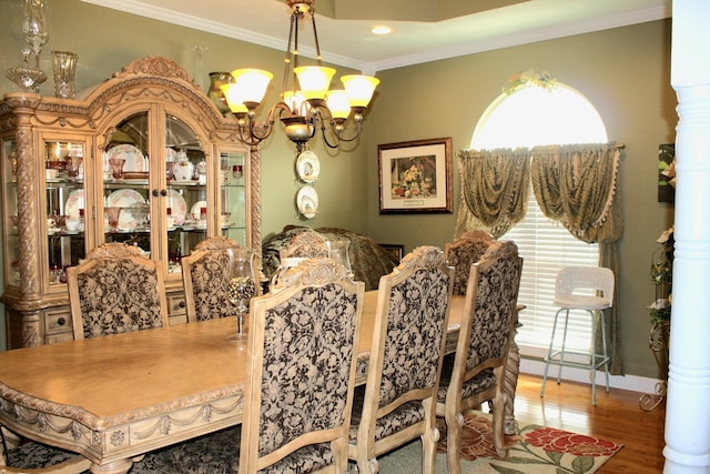 dining room featuring an inviting chandelier, ornamental molding, and hardwood / wood-style floors