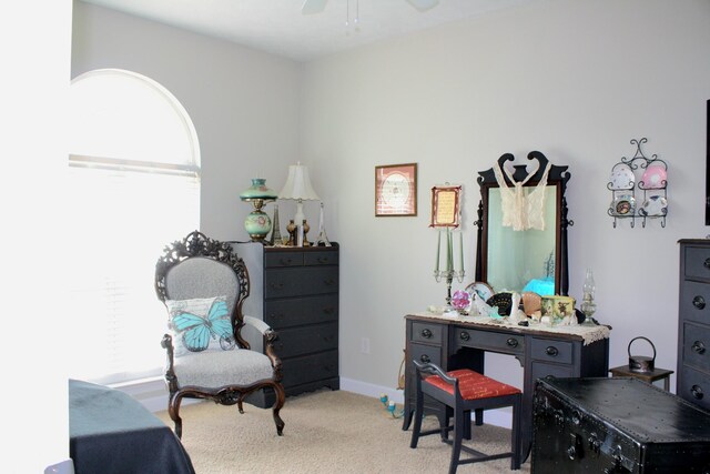 interior space featuring light carpet, multiple windows, and ceiling fan