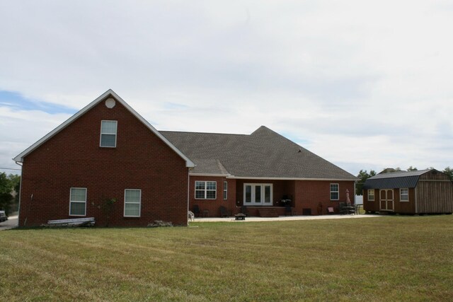 view of front facade featuring a front yard and a storage shed