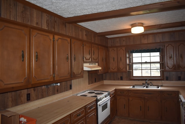 kitchen with a textured ceiling, white range, sink, and wooden walls