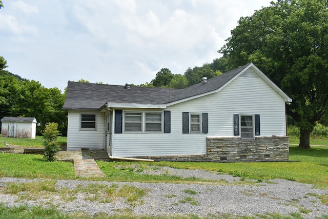 view of front of property with a shed and a front lawn