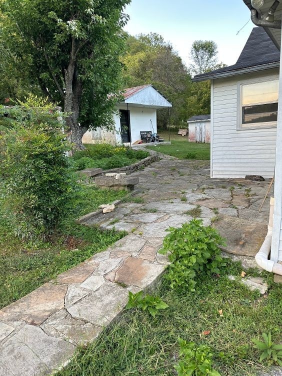 view of yard with an outdoor structure and a patio area