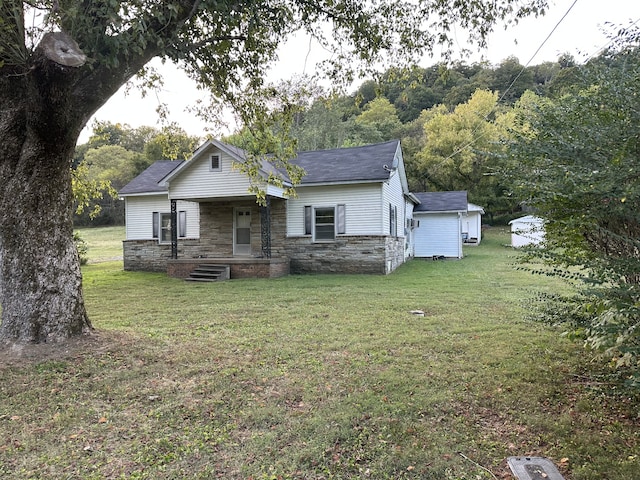 view of front of property with a front lawn and a shed