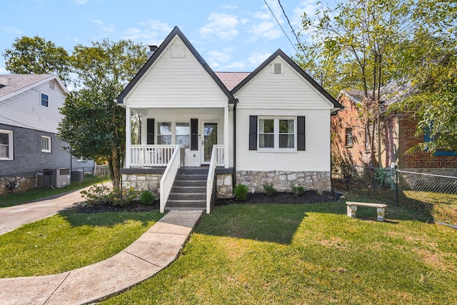 bungalow-style house featuring cooling unit, a porch, and a front lawn