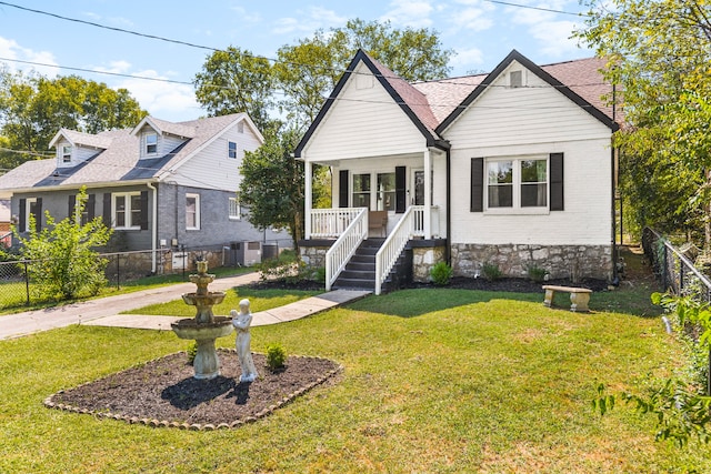 view of front facade with cooling unit, a front yard, and a porch