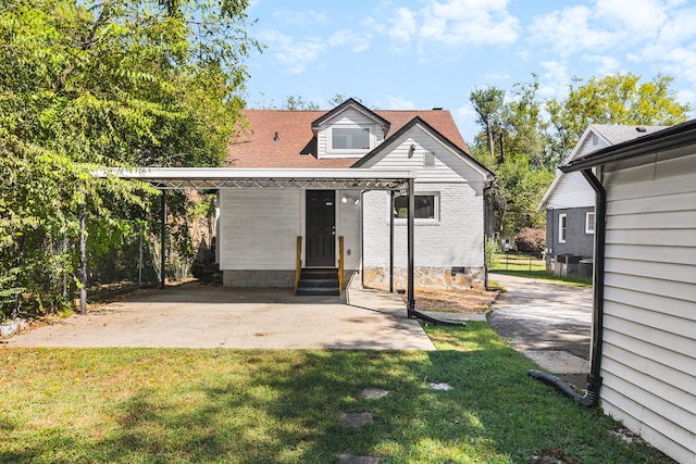 rear view of property featuring a yard and a carport