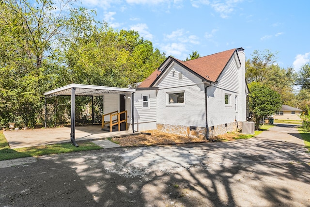 view of side of property with cooling unit and a carport