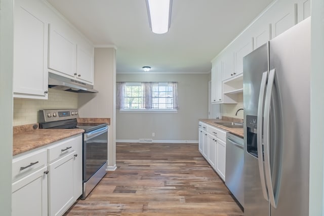 kitchen featuring light hardwood / wood-style floors, white cabinets, stainless steel appliances, crown molding, and sink