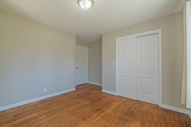 unfurnished bedroom with light wood-type flooring and a closet