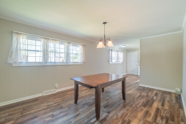 dining area with ornamental molding, an inviting chandelier, and dark hardwood / wood-style flooring