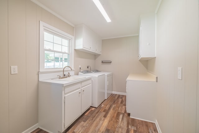 laundry room featuring independent washer and dryer, cabinets, ornamental molding, hardwood / wood-style floors, and sink