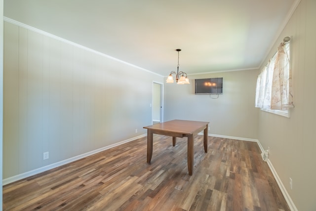 dining area with ornamental molding, a chandelier, and dark wood-type flooring