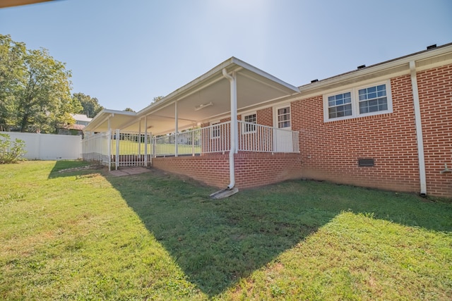 rear view of property featuring a lawn