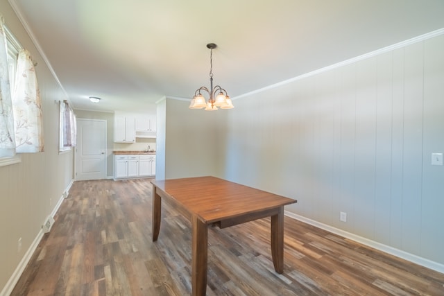 dining area featuring ornamental molding, dark hardwood / wood-style flooring, a chandelier, and sink