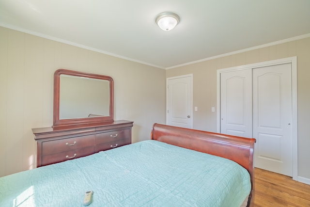 bedroom with light wood-type flooring, a closet, and crown molding