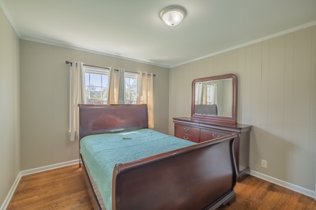 bedroom with ornamental molding and dark hardwood / wood-style floors