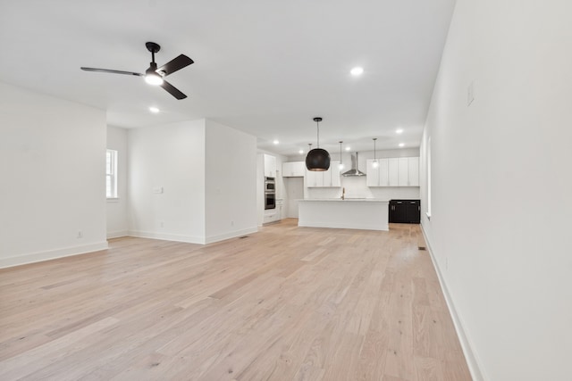 unfurnished living room featuring ceiling fan and light hardwood / wood-style floors