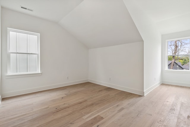 additional living space featuring light hardwood / wood-style floors and lofted ceiling