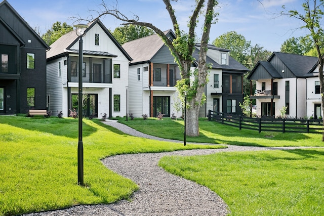 view of front of house featuring a sunroom and a front yard