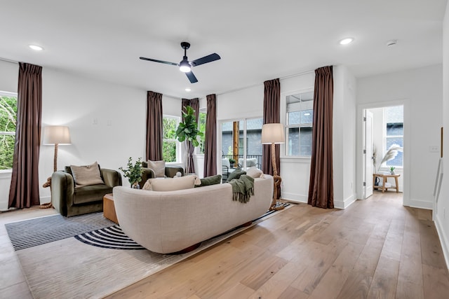 living room featuring light hardwood / wood-style floors and ceiling fan