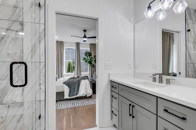 bathroom featuring ceiling fan, a shower with door, vanity, and wood-type flooring