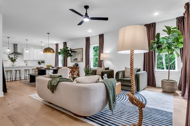 living room featuring ceiling fan, a healthy amount of sunlight, and light hardwood / wood-style flooring