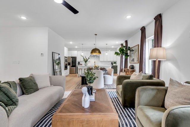 living room featuring ceiling fan and light wood-type flooring