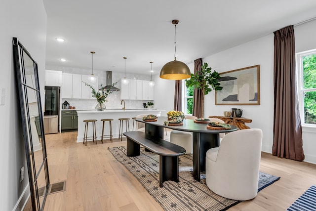 dining space with light hardwood / wood-style flooring and sink