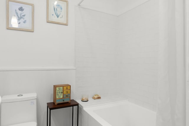 bathroom featuring toilet and a tub