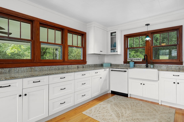 kitchen featuring sink, white dishwasher, pendant lighting, light stone countertops, and white cabinets