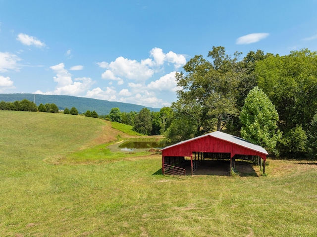 view of home's community featuring a rural view, a yard, and a water and mountain view