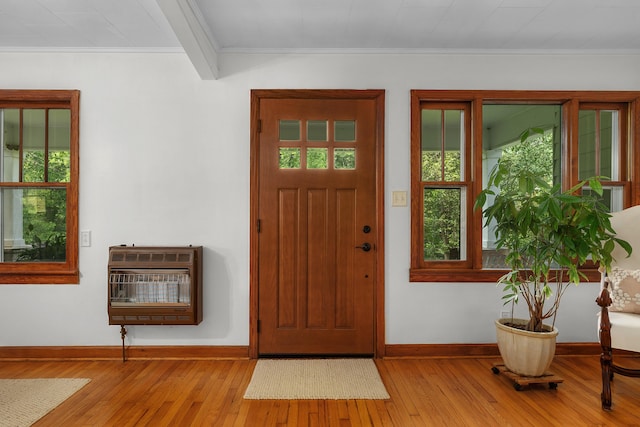 foyer with ornamental molding, heating unit, and light hardwood / wood-style flooring